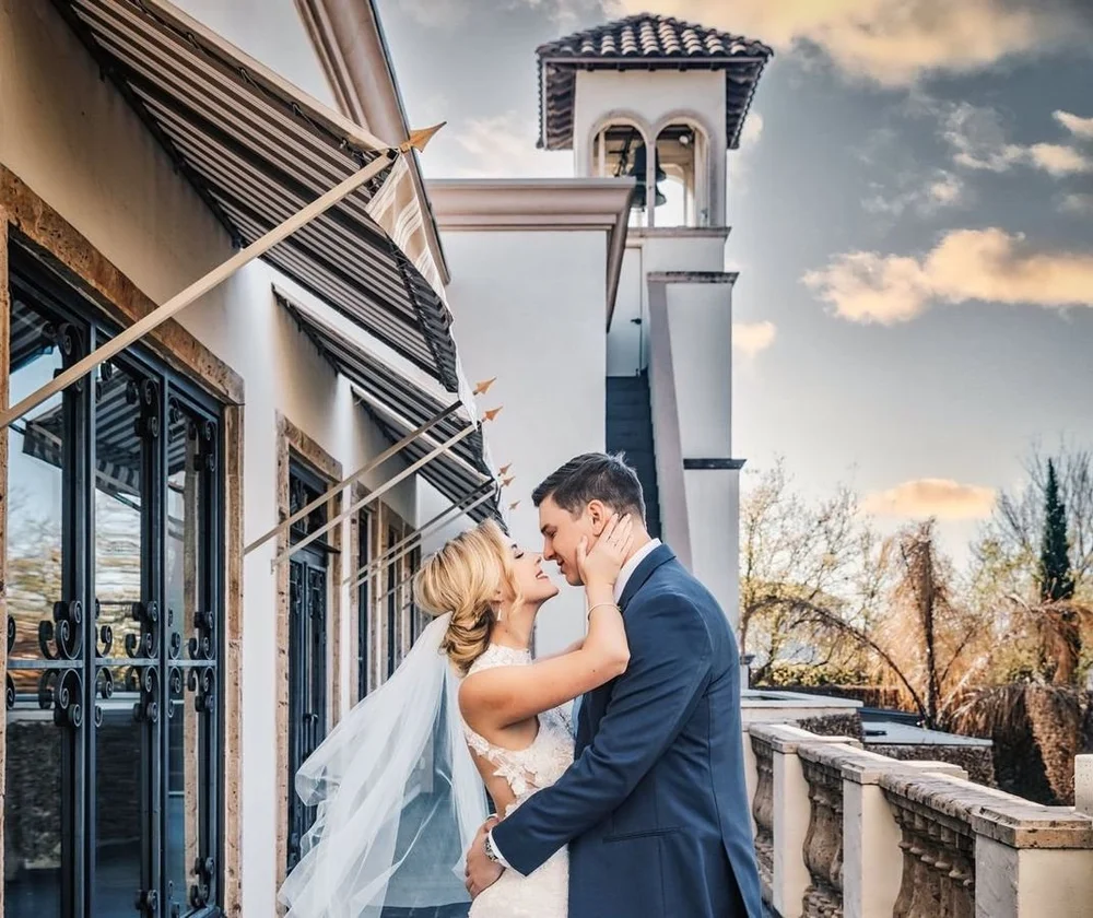 Couple kissing on the terrace balcony of The Bell Tower on 34th, Houston, TX.